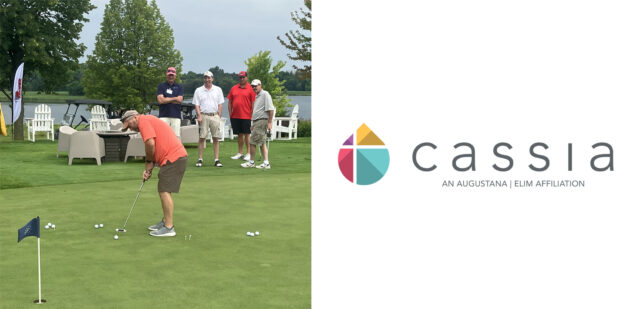 A golfer stands on the putting green getting ready to hit the ball.