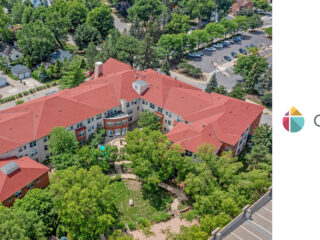 Aerial view of The Pines of Richfield, an 83-unit assisted living community with red roofs, surrounded by lush greenery and a quiet residential neighborhood.